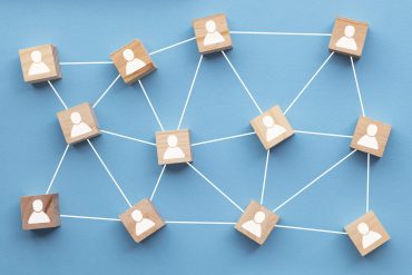 Wooden blocks connected together on a blue background. Teamwork concept