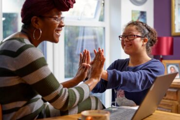 Mother with daughter with Down Syndrome playing at home